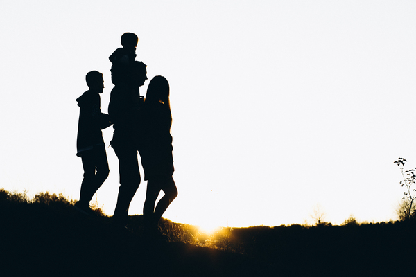 Silhouette Of A Family Walking By The Sunset Time